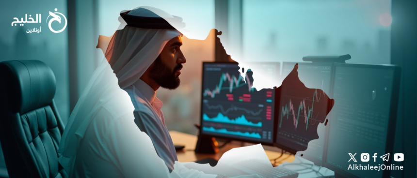 An Arab man in traditional attire working at a desk with multiple computer screens displaying stock market charts