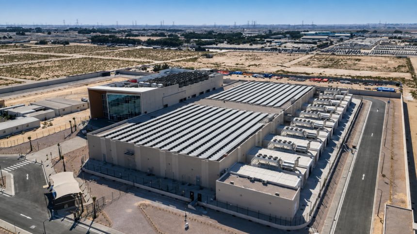 A large data center complex in the Gulf surrounded by desert infrastructure and power transmission lines