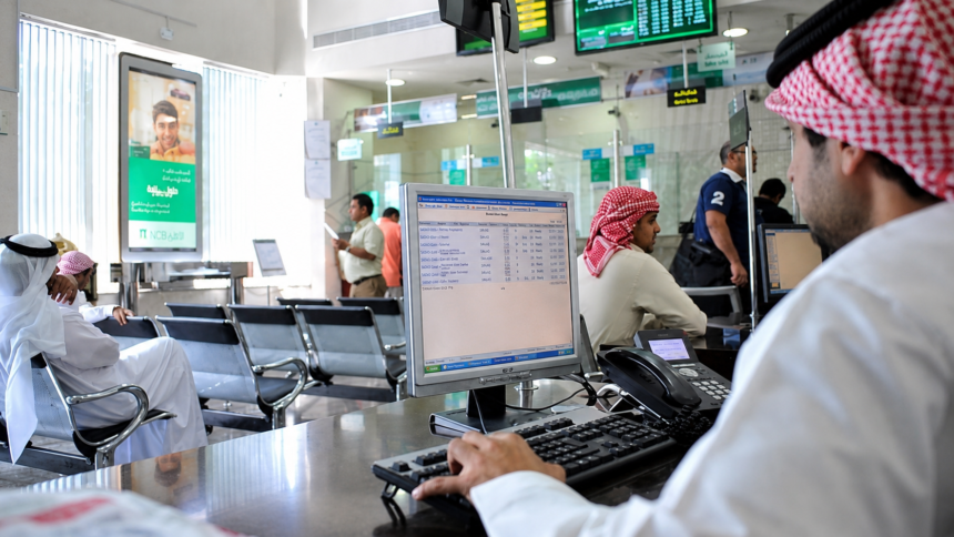 Saudi bank branch with customers and employees using digital banking systems