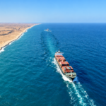 Cargo ship sailing along a desert coastline in the Red Sea-Arabian Sea corridor