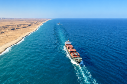Cargo ship sailing along a desert coastline in the Red Sea-Arabian Sea corridor