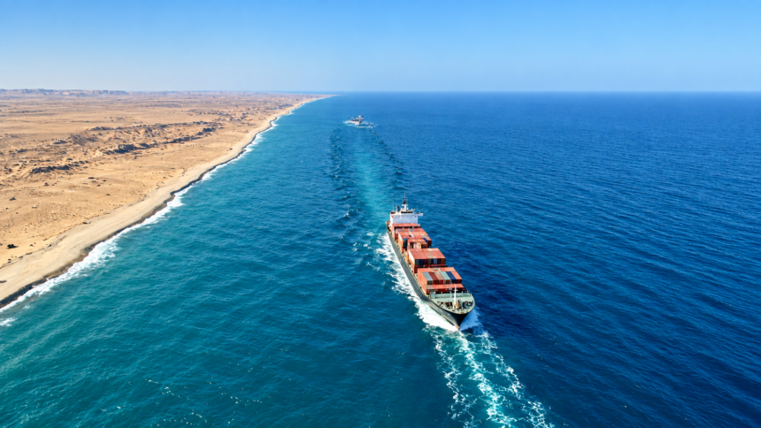 Cargo ship sailing along a desert coastline in the Red Sea-Arabian Sea corridor